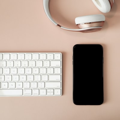 白色苹果键盘和白色无线电脑鼠标旁边的黑色iPhone7